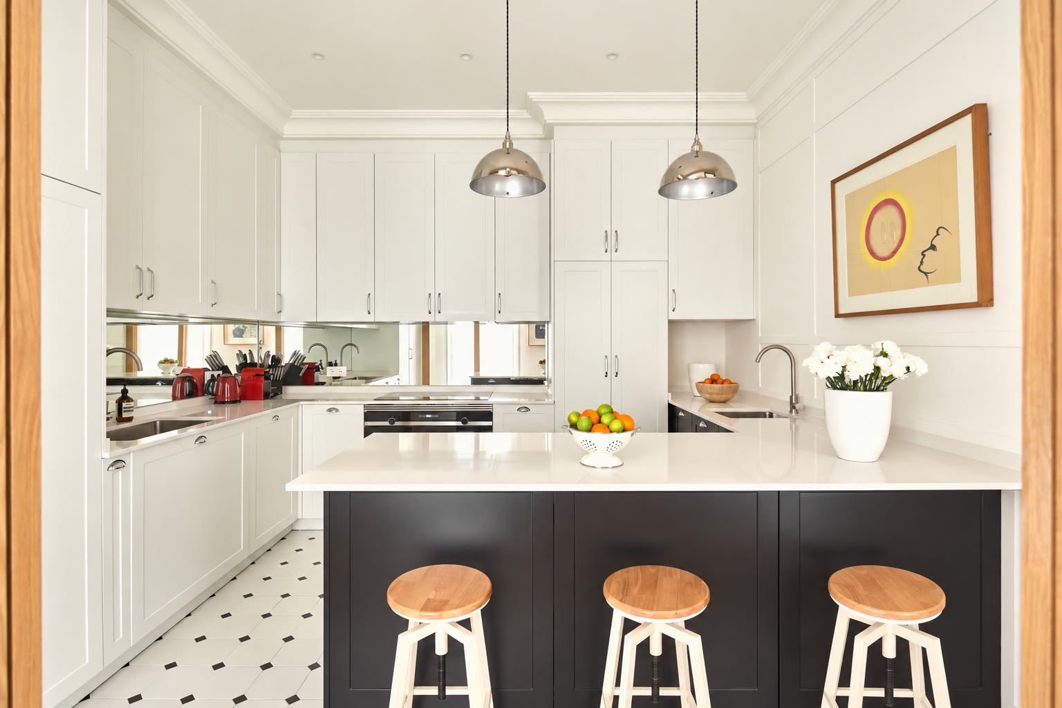 White shaker kitchen with navy breakfast bar and wooden stools