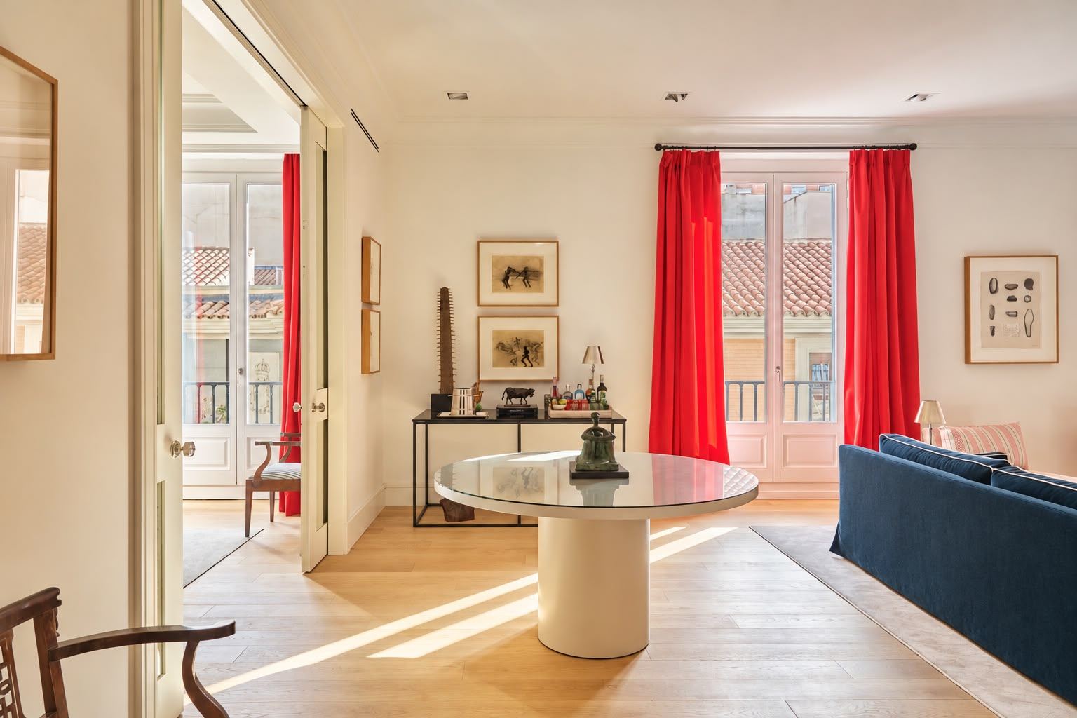 Round lacquered table in sunlight, bar console and balcony